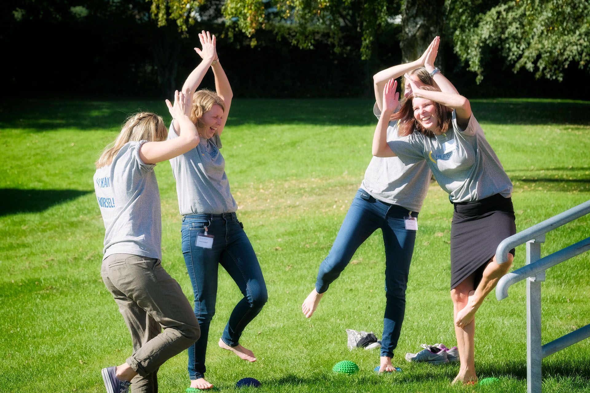 Fire unge personer trener balanse utendørs i solen