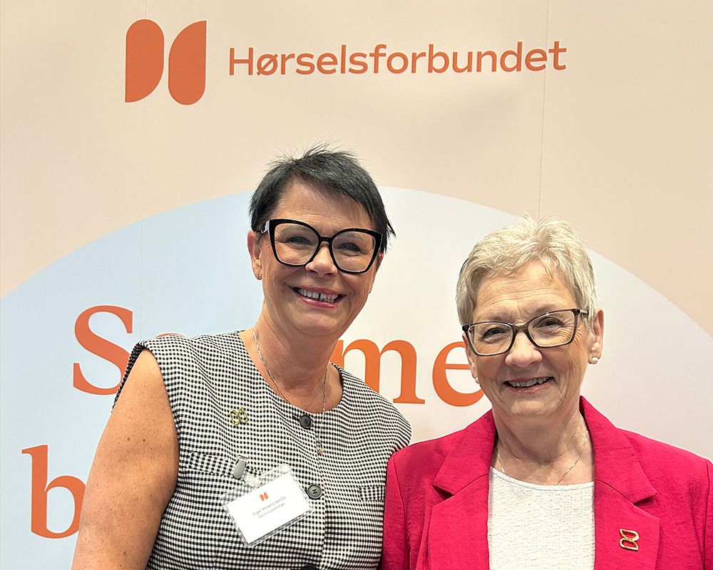 Smilende kvinner under ny logo for Hørselsforbundet